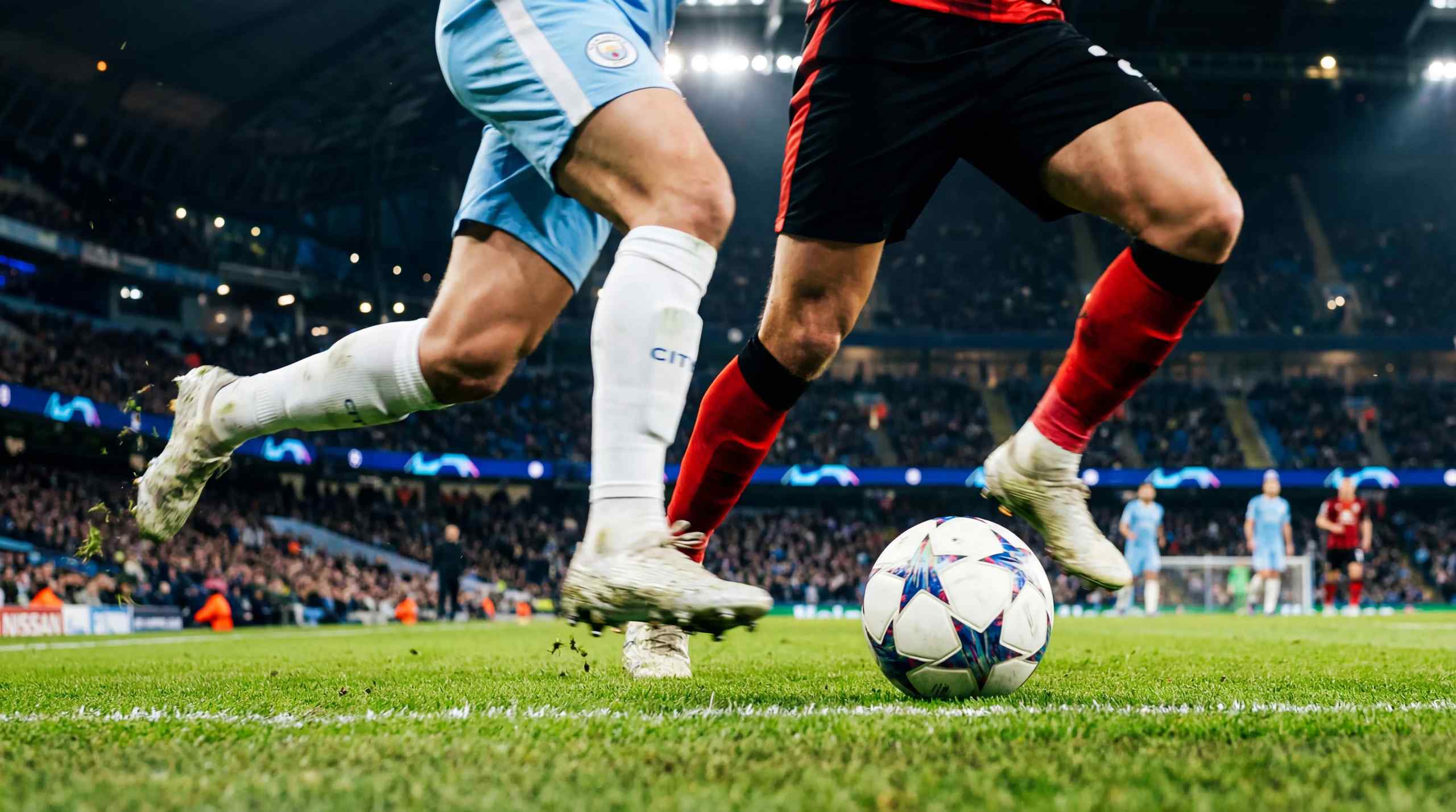 A photo of a Champion's League match involving Manchester City. The Champion's League football is featured prominently.